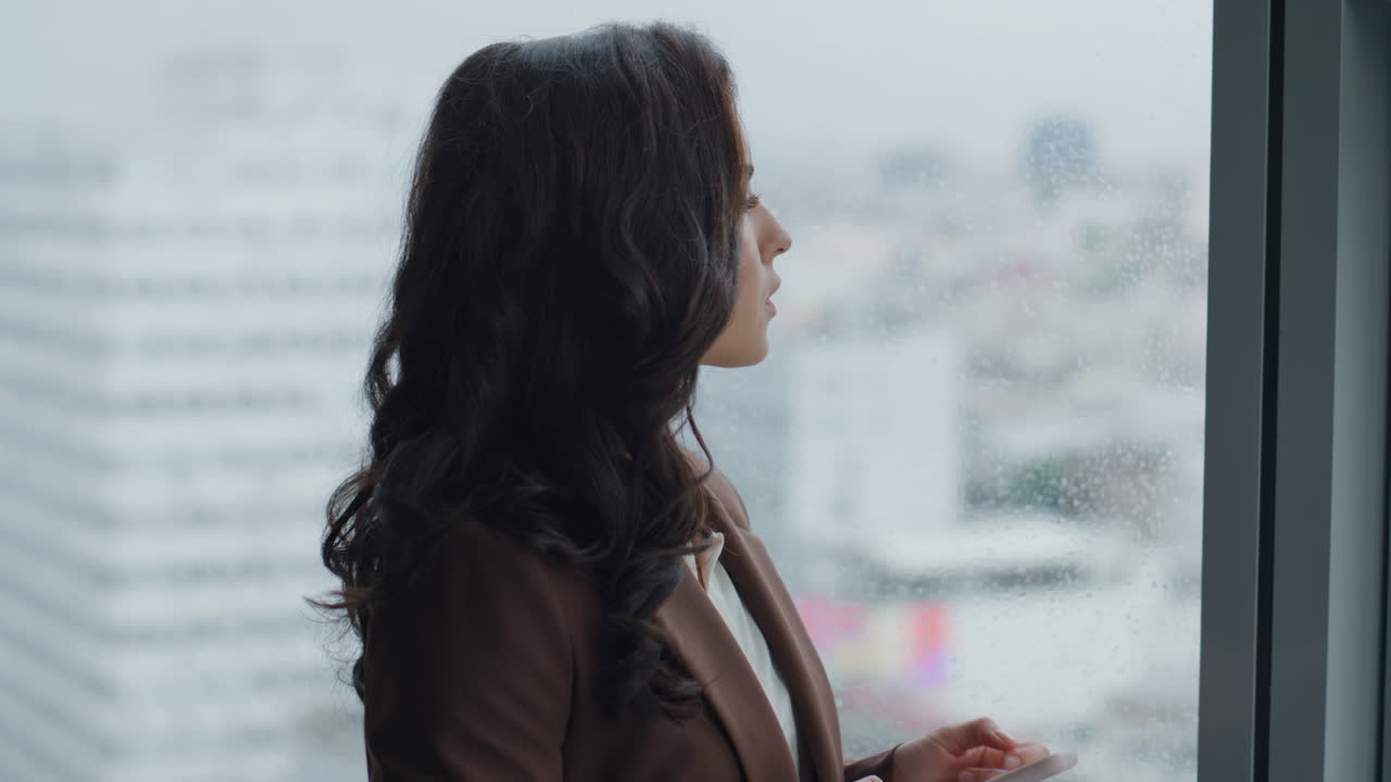 mujer de negocios desplazando el teléfono inteligente de pie en la ventana de cerca. niña escribiendo.