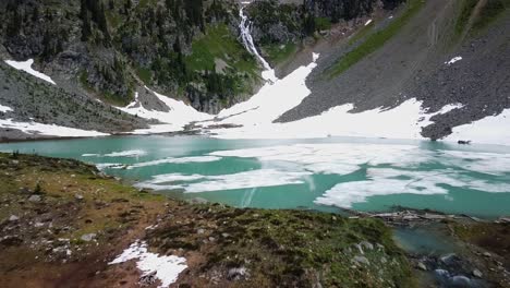 Flying-low-above-turquoise-crystal-clear-alpine-lake,-aerial-shot,-West-Kootenays,-2-of-2