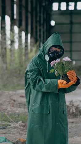 man in protective uniform and gas mask. post apocalyptic character with a gun standing in abandoned hangar