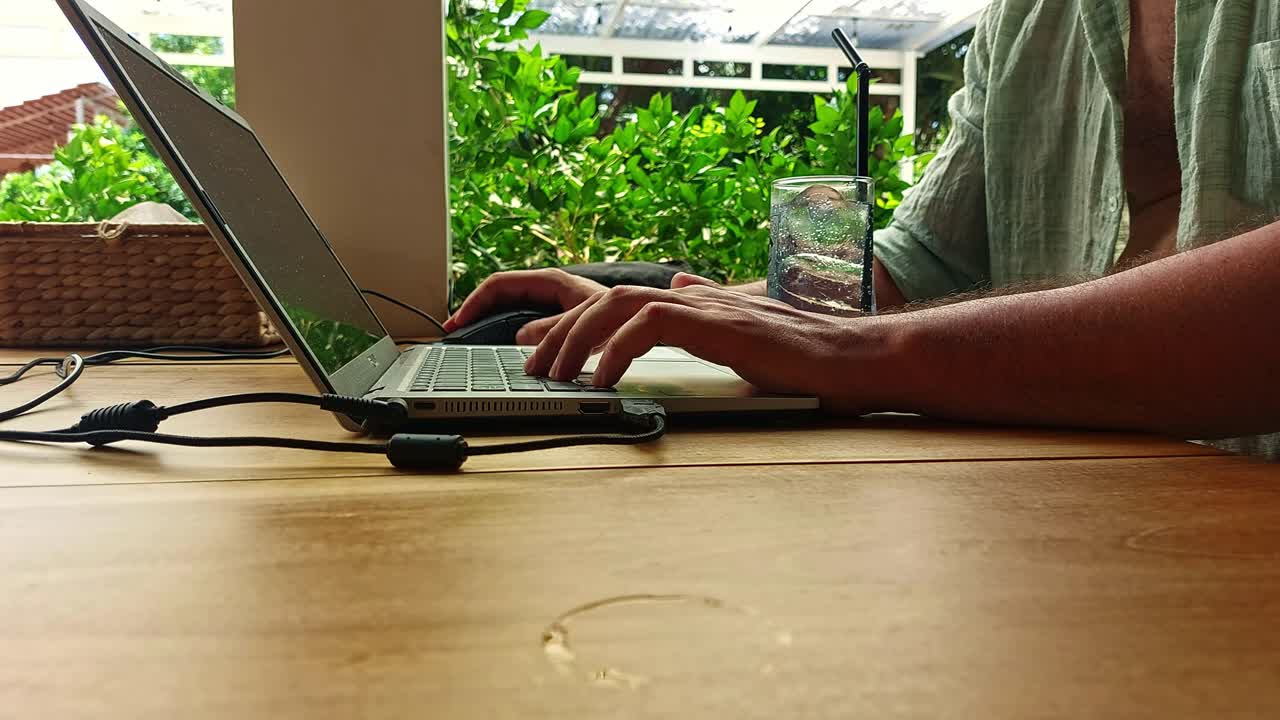 Close up to a digital nomad working remotely while on a summer holiday vacation
