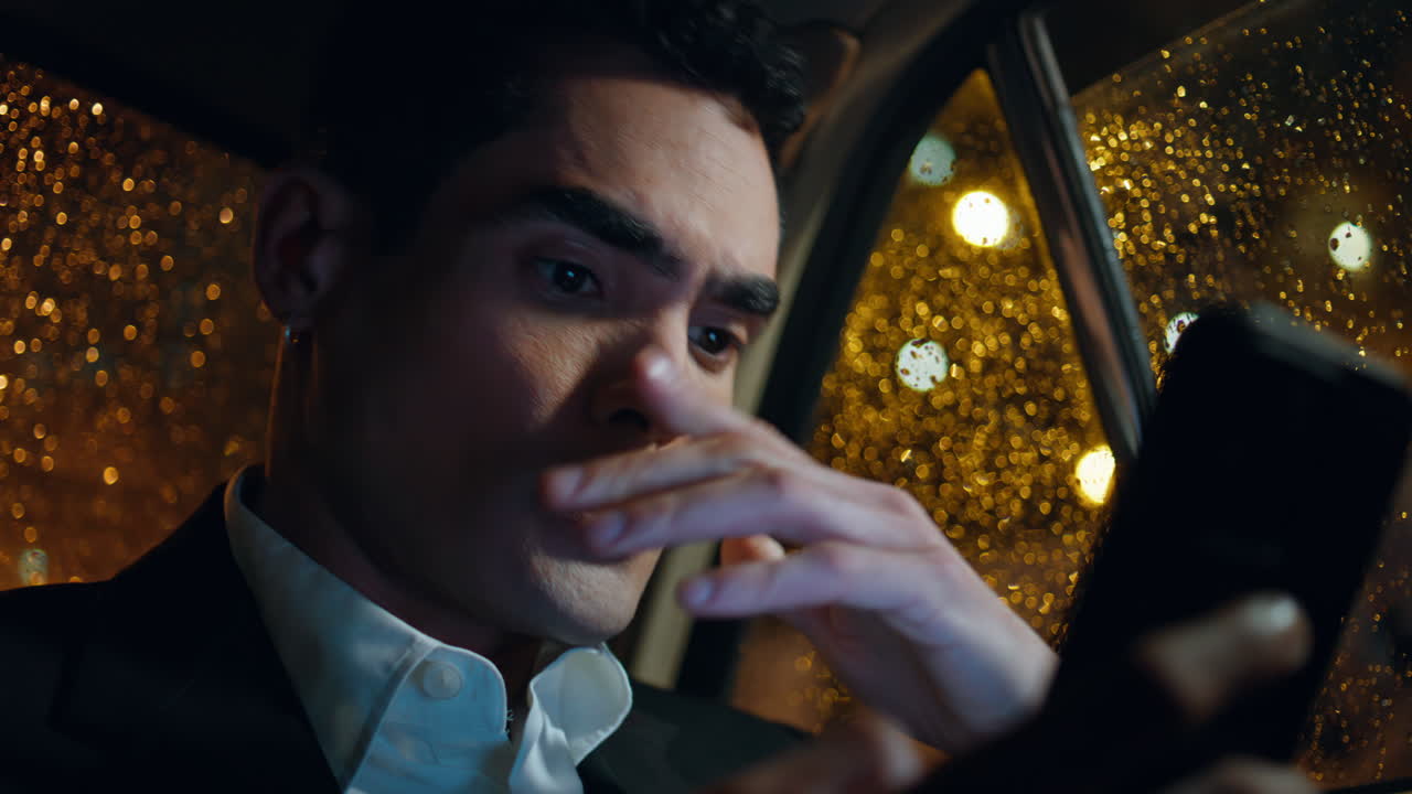 Stressed man using smartphone in car closeup. Nervous passenger reading email