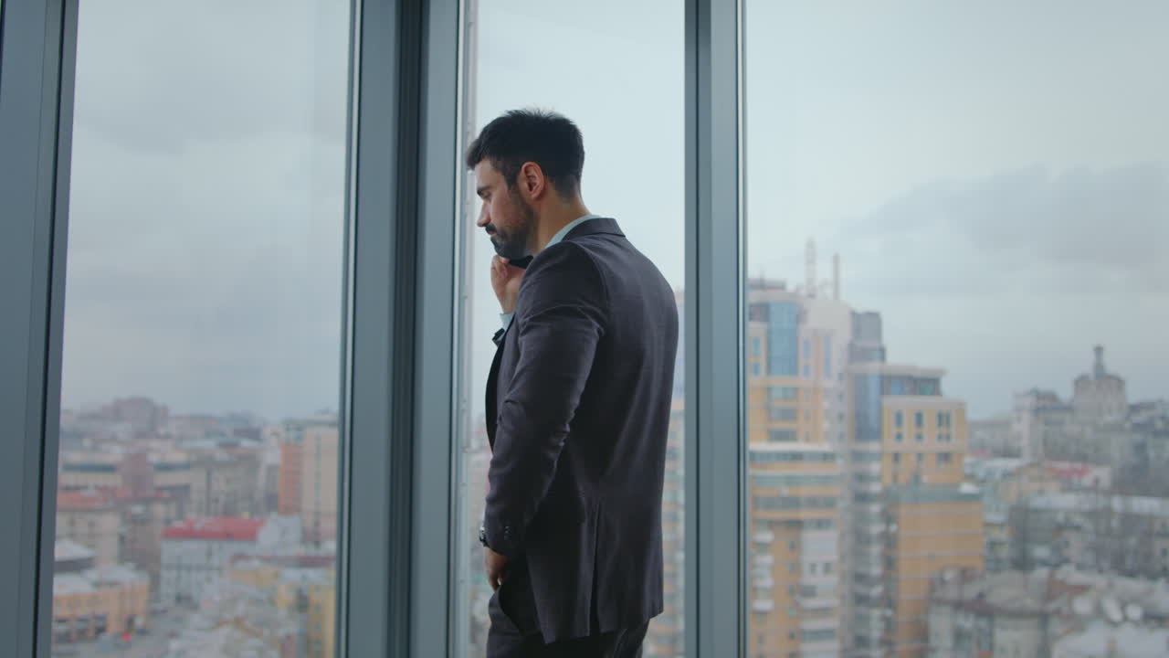 ceo ocupado llamando a los socios de pie en la ventana de la oficina. jefe dando tareas por teléfono