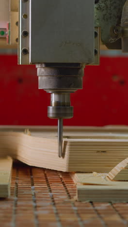 máquina cnc en funcionamiento, primer plano detallado de la broca de perforación tallando un patrón en madera contrachapada en un taller