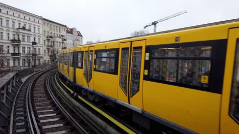 public transportations in berlin with yellow color leaving train station