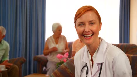 Portrait-of-female-doctor-with-senior-people-in-background