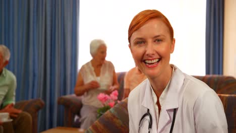 portrait of female doctor with senior people in background