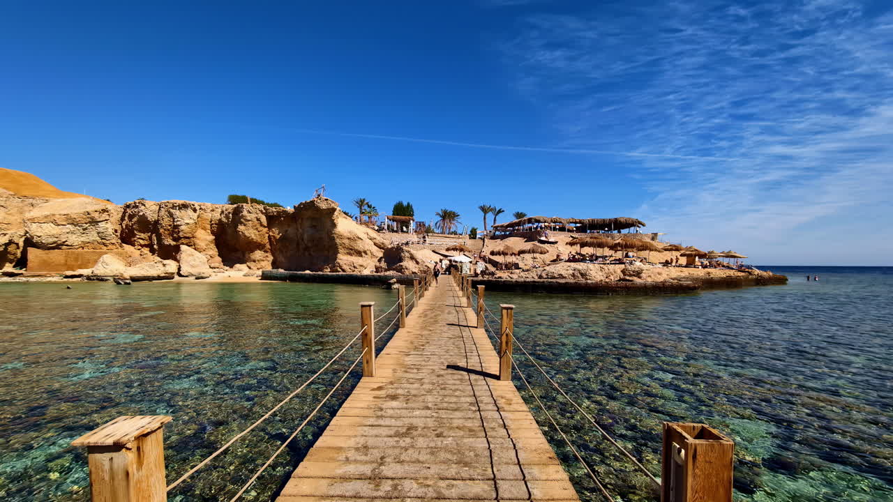 Walking on wooden footbridge to cross a gulf of shallow water