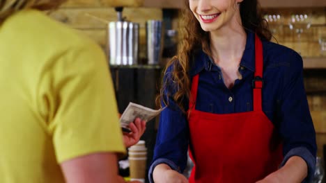 Female-costumer-paying-bill-to-waitress-at-counter