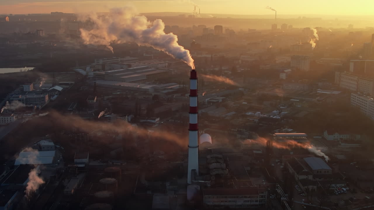 Aerial drone view of thermal power plant in Chisinau at sunrise, Moldova. View of pipe with felling steam, cityscape