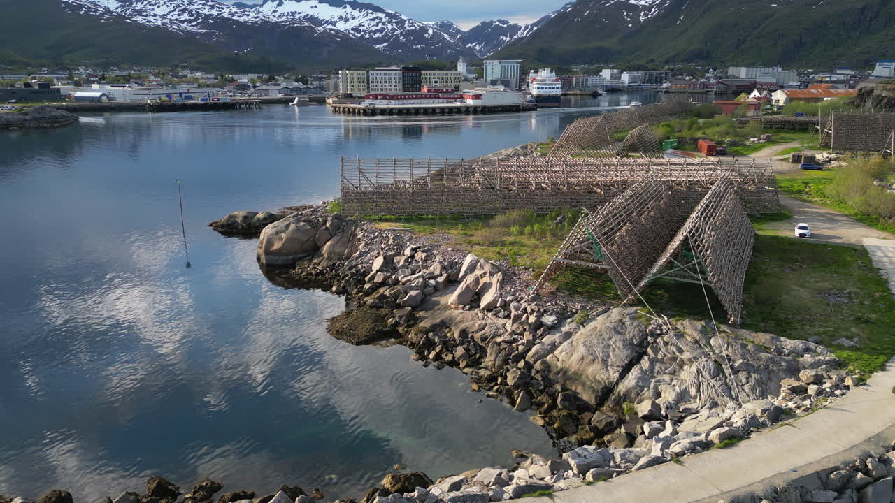 Traditional wooden structures drying skrei cod in Lofoten Islands, Norway, create a captivating scene
