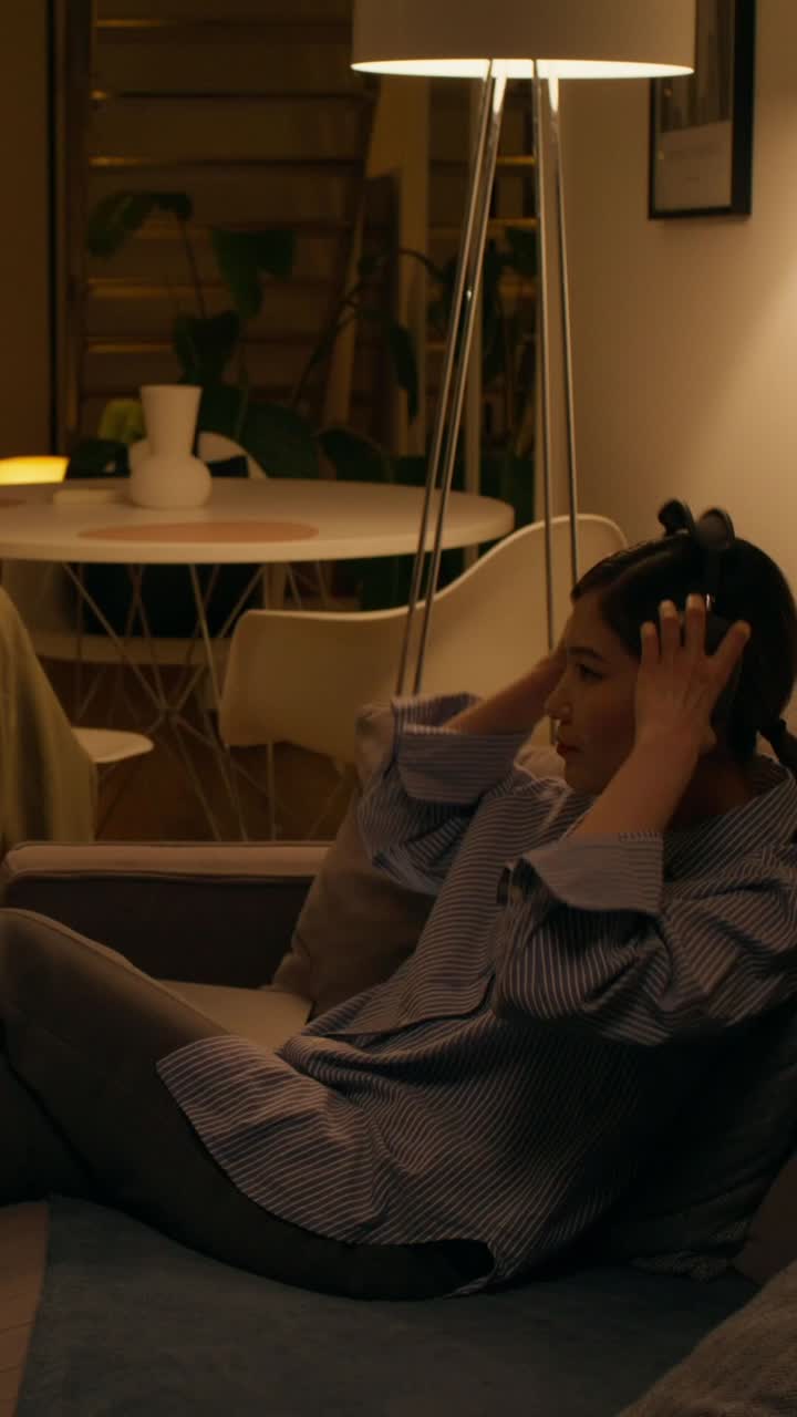 Donna che si rilassa a casa con cuffie e telefono
