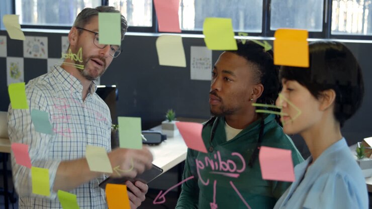 Business executives discussing over sticky note in office 4k