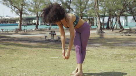 relajante mujer estirando la columna vertebral en la pradera