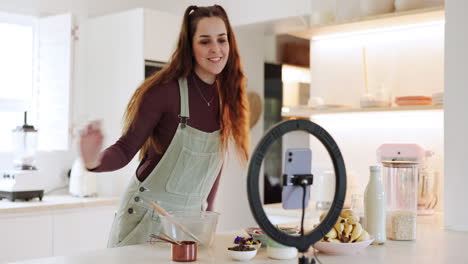 Woman,-phone-and-live-streaming-in-kitchen