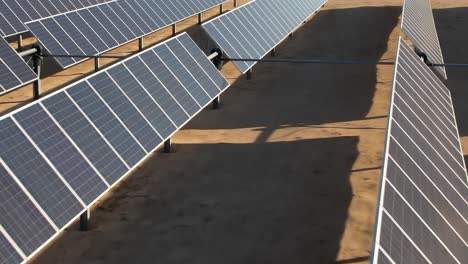 aerial over up close solar panels, photovoltaic farm of energy powered by the sun