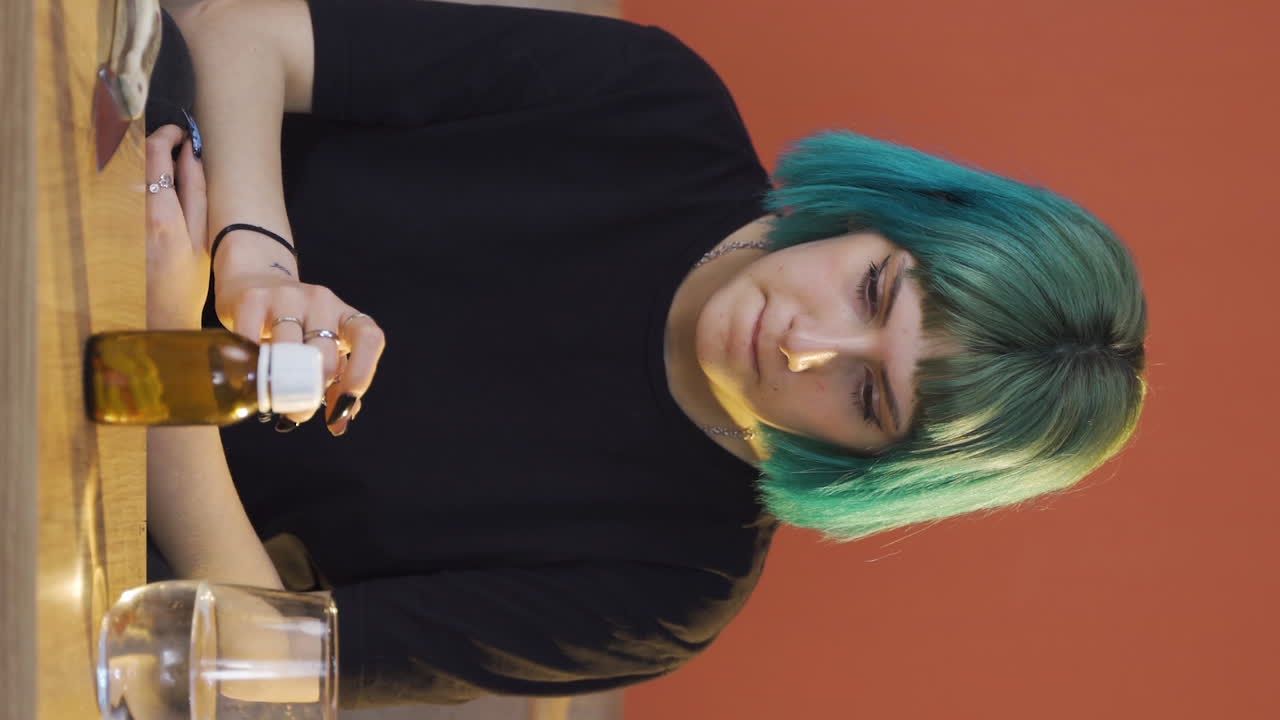 Video vertical de la joven que mira las pastillas en su mano