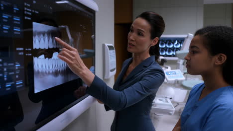 dental professionals examining digital dental scans on a large screen
