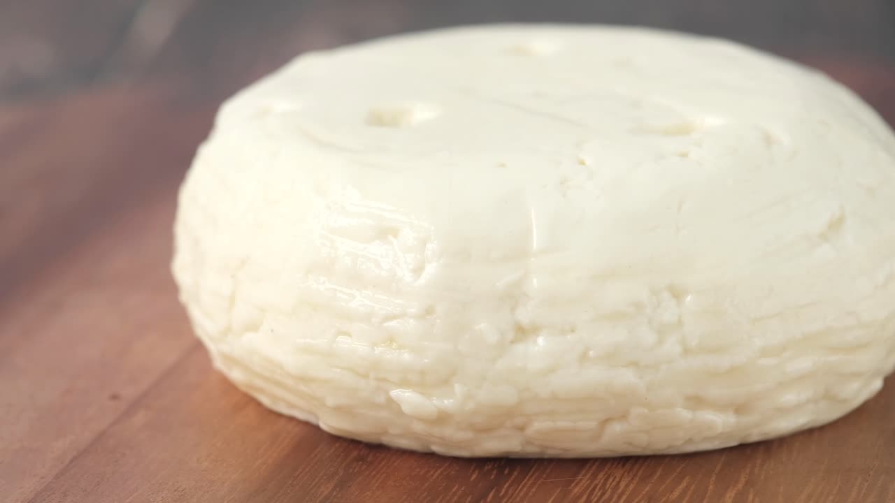 queso blanco redondo en una tabla de madera