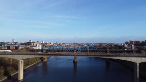 cars driving across bridges in newcastle upon tyne quayside on sunny autumn day - aerial drone 4k hd footage rise up