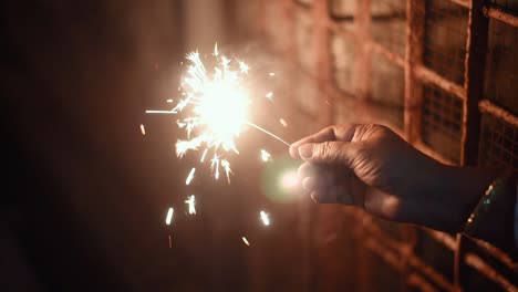 hand holding firecrackers at night celebrating new year, indian festivals