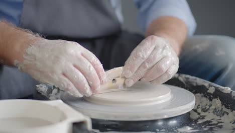 close-up of the hand of a master working on a potter's wheel for the manufacture of clay and ceramic jugs and plates in slow motion