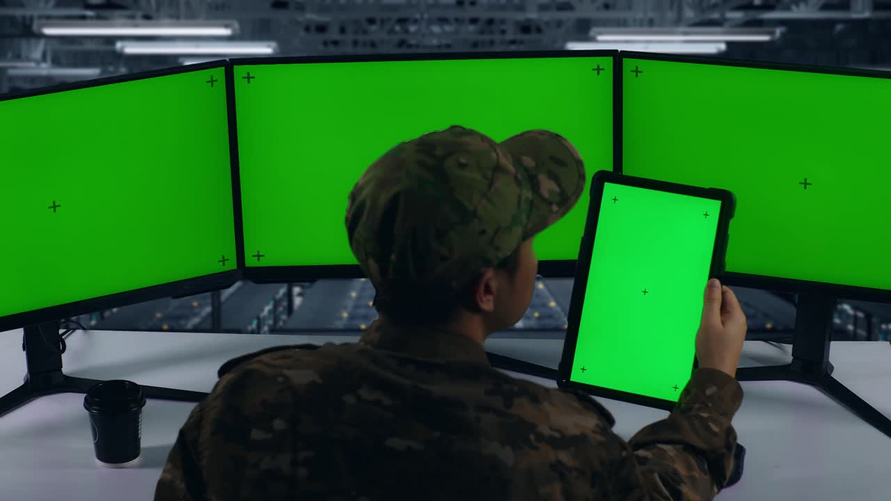 vista trasera de militares asiáticos trabajando con tableta y múltiples monitores de computadora con pantalla verde simulada en el centro de datos