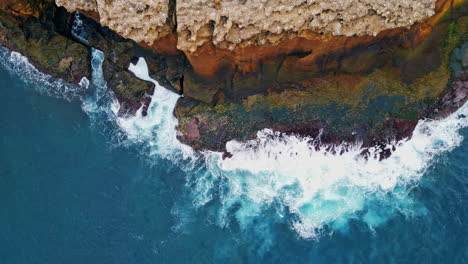 powerful waves splashing cliffs coastline. aerial stormy ocean hitting rocky