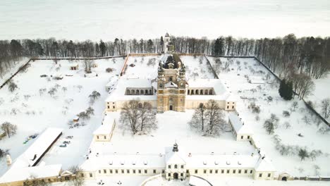 aerial view of the pazaislis monastery and the church of the visitation in kaunas, lithuania in winter, snowy landscape, italian baroque architecture, zooming in