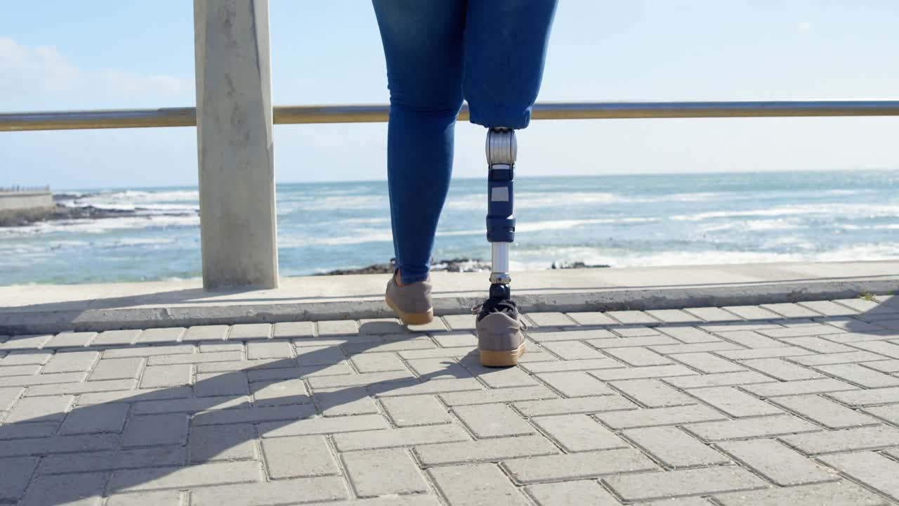 4k 레일링 근처의 산책로를  ⁇ 고 있는 장애인 여성의 낮은 섹션