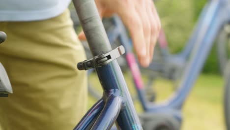 persona que ajusta la altura del asiento de la bicicleta