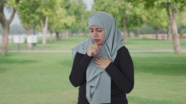 mujer musulmana enferma que sufre de fiebre en el parque