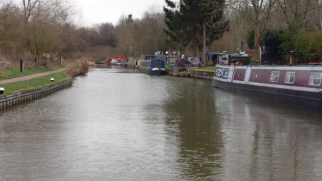 a canal with narrow house boats mooring on a river