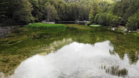 Drone-video-over-mountain-alpine-lake-Moutsalia-Gramos-summer-low-angle