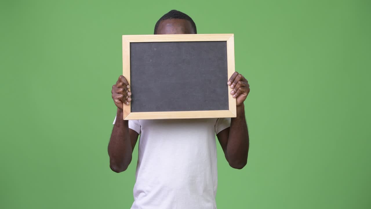 un jeune homme africain montrant un tableau noir