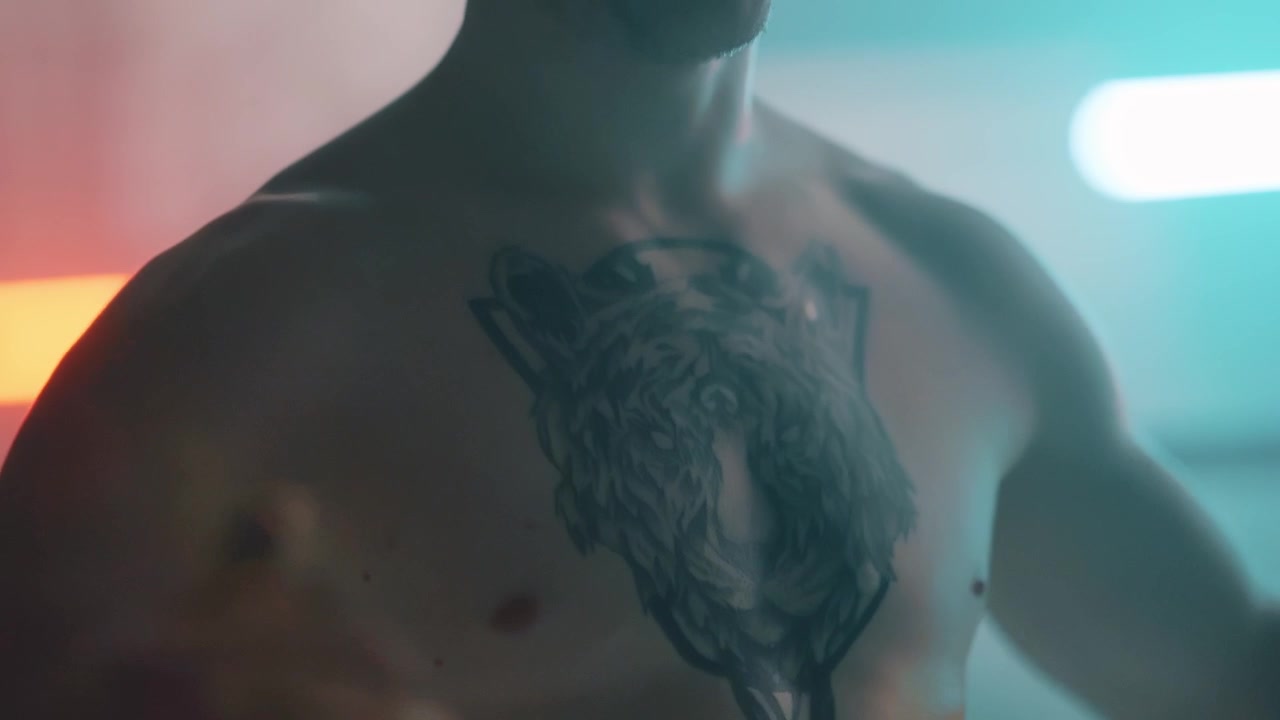 Homem Musculoso com Tatuagem de Lobo no Peito sob Iluminação Neon.