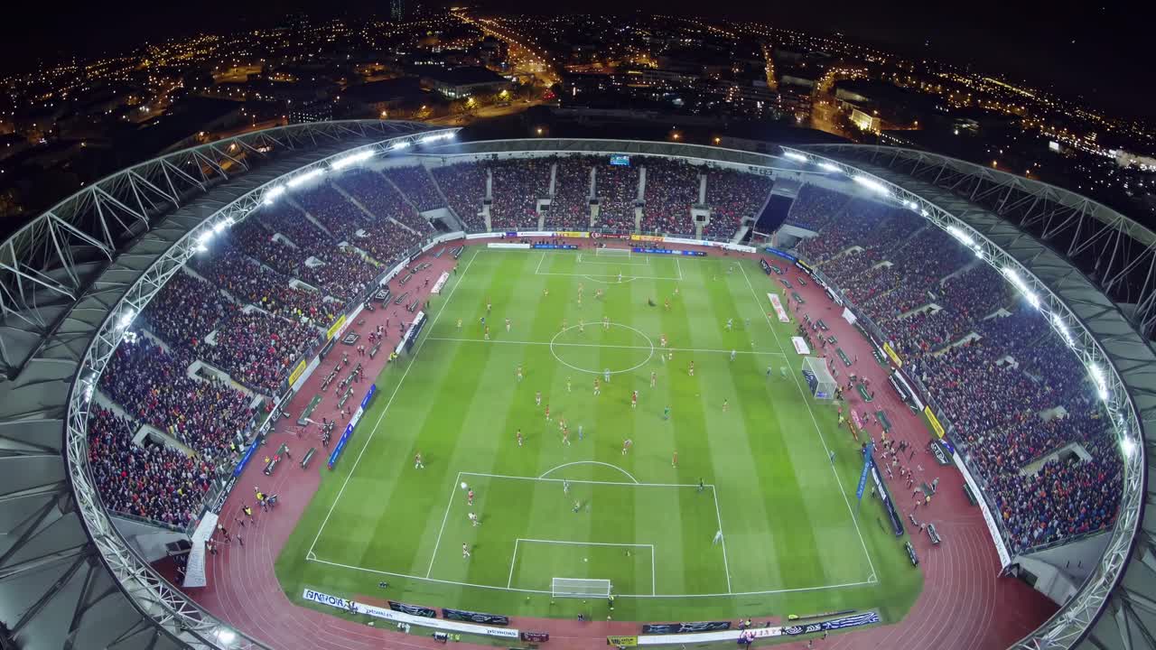 Vista aerea di una partita di calcio in uno stadio affollato di notte