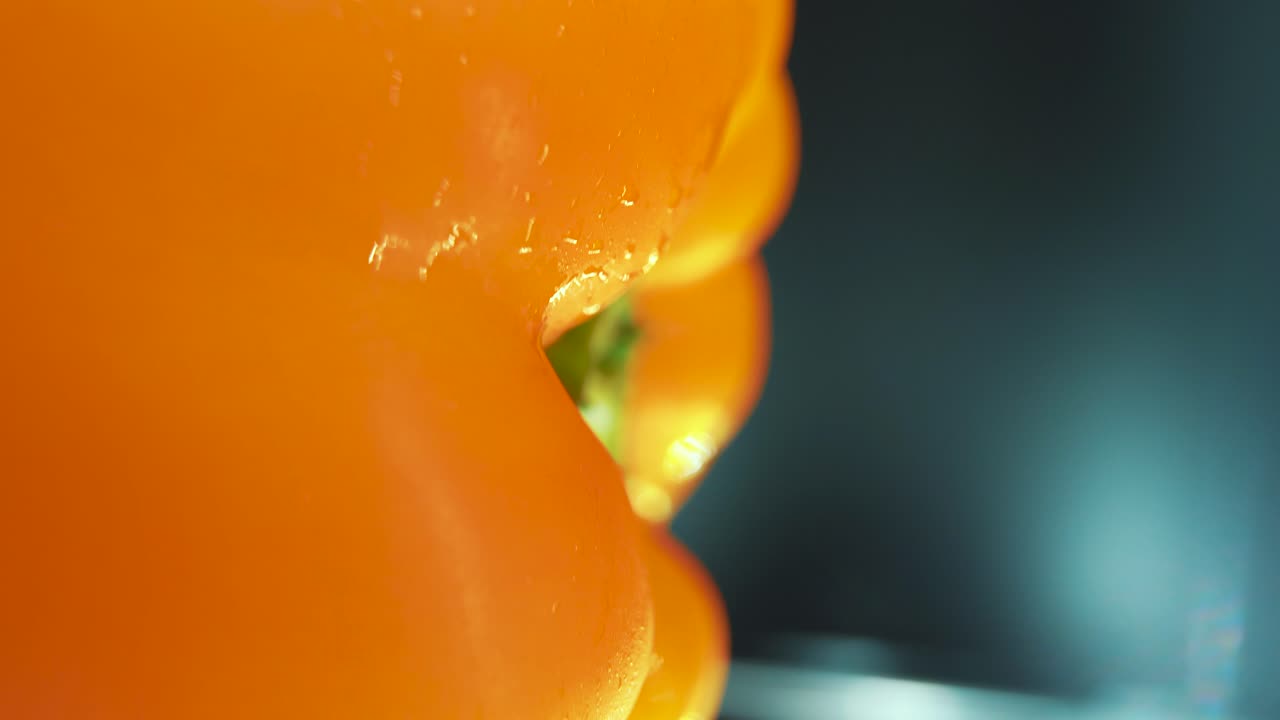 360 회전 스탠드에  ⁇ 은 달 ⁇ 한 노란 고추의 수직 매크로 클로즈업  ⁇ , 반 ⁇ 이는  ⁇ 이 나는 물방울, 영화 스튜디오 조명, 느린 동작, 4k 비디오