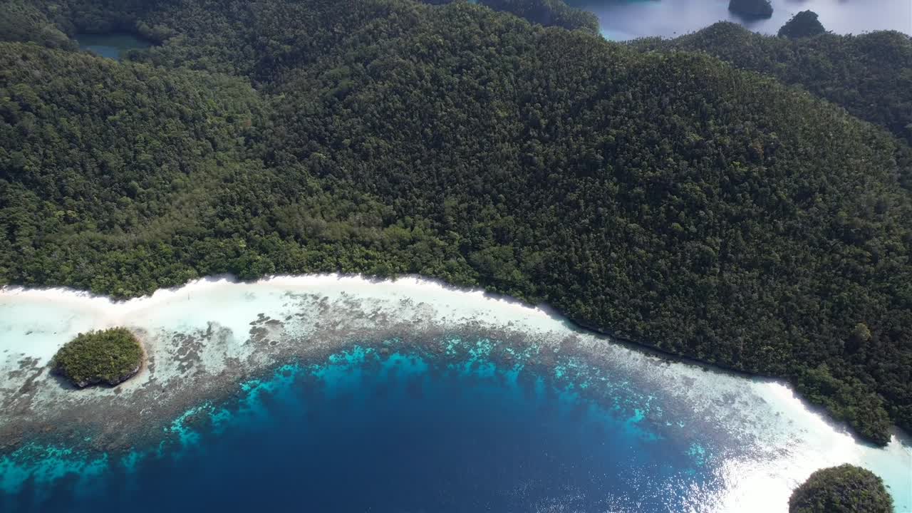 View on lagoons, island with white sand beach, rock formations and phinisi ship in Raja Ampat, Wayag, Indonesia