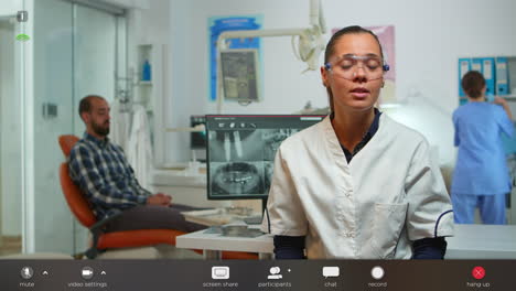stomatologist doctor talking on web cam with patients