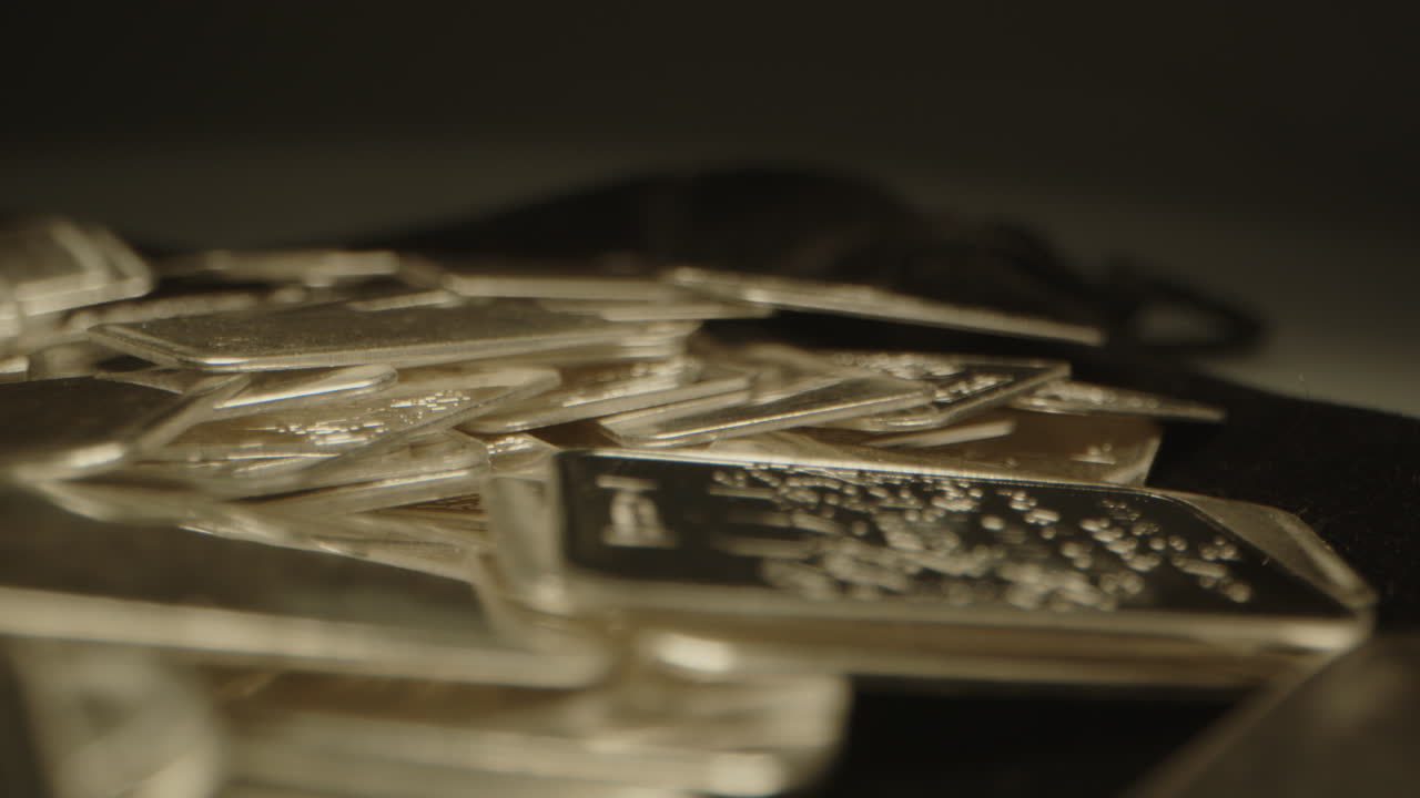 Stunning macro dolly of shiny silver plates on a velvet surface. The camera gently moves over the precious metal plates