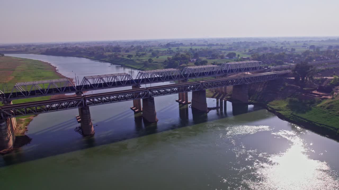 goods train moving on track with tons river and farming land at day time, orbit shot, drone shot, 4k.