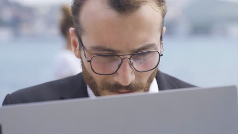 Businessman-working-on-laptop-outdoors.