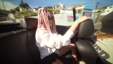 woman with braids enjoying a sunny convertible ride