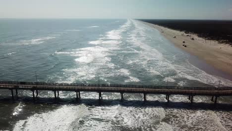 Vista-Aérea-De-Drones-Del-Muelle-Largo,-Gente-En-La-Playa,-Dunas-Y-Olas-En-El-Parque-Costero-Del-Condado-De-Nueces-En-La-Isla-Del-Padre-Norte,-Texas