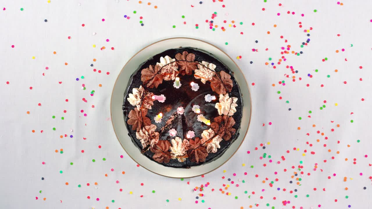 trayendo el pastel de cumpleaños con velas encendidas y soplándolas