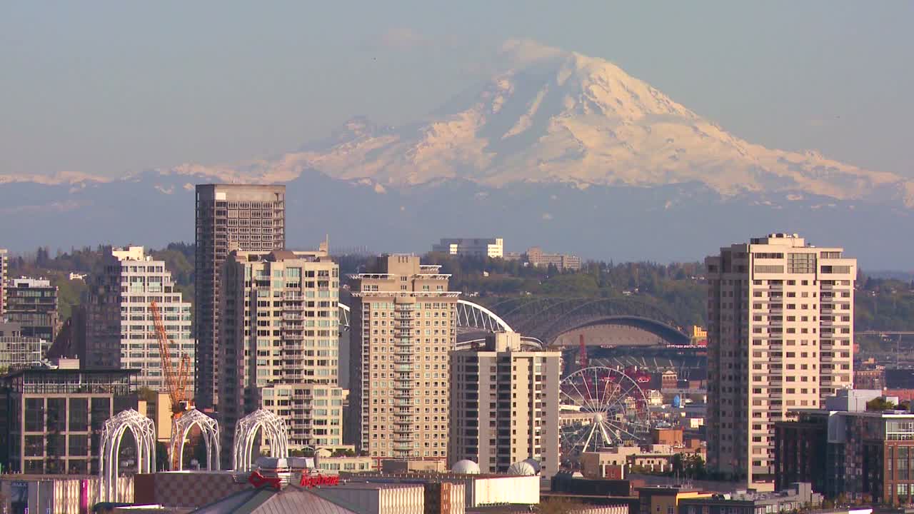 foto de teleobjetivo del monte rainier que se cierne sobre el horizonte de seattle, washington