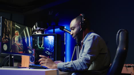 smiling gamer with headphones on relaxing in gaming room, chatting