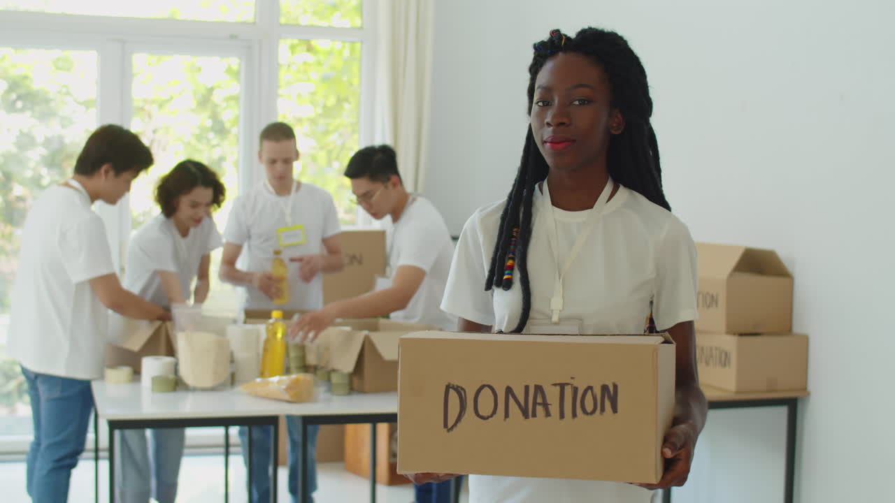 Portrait of Black Woman Holding Box with Products for Donation