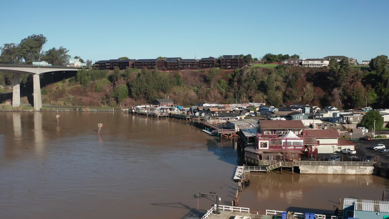 Aerial low rising shot of a lodge on a cliff overlooking Noyo Harbor in Fort Bragg, California. 4K