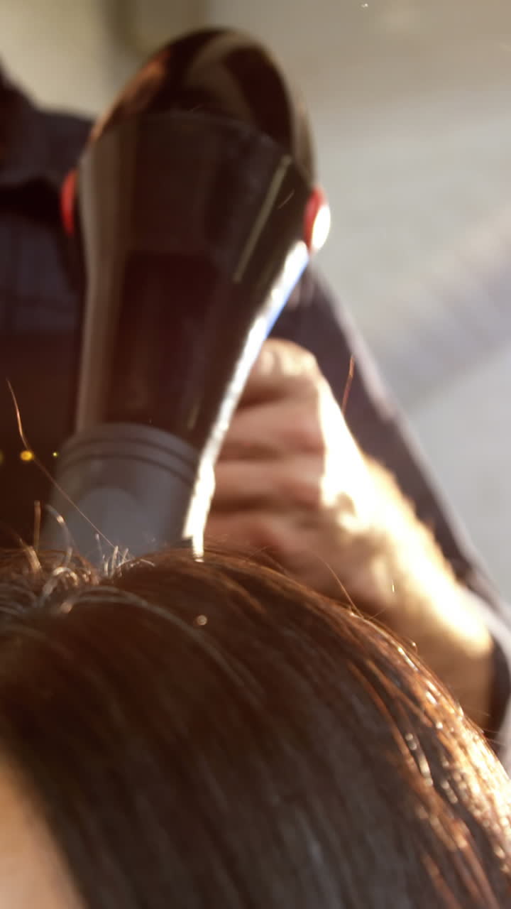 Woman getting his hair dried with hair dryer